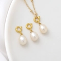 Detailed view of high-luster teardrop freshwater pearls with gold spring clasps on white satin - Gold
