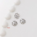 Dettaglio macro di tre coppette per perline a fiore argento da 7mm per gioielli - Placcato Oro Bianco Stile 18