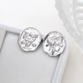 Macro detail of silver owl and Greek portrait pendant on white jewelry box tray - Style 2