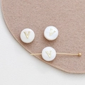 Detailed macro view of white shell beads with golden metal V initial for DIY jewelry making - Letter V (22#V Single Price)