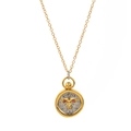 Close-up of gold and silver pendant with leopard head carving and red gemstone eyes - Leo
