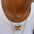 Elegant layered gold bow pendant necklace with pearl details worn on model - Stainless Steel / Medium Bowknot