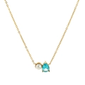 Detalle macro del collar dorado con circonita azul en gota y una perla blanca pura - Marzo