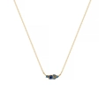 Close-up of titanium steel gold chain necklace featuring five blue gemstones in a row - December