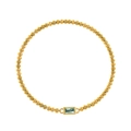 Detailed macro view of golden beaded bracelet with rectangular light blue birthstone - March