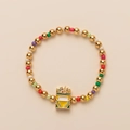 Detail of colorful beads and gold spheres with crown enamel pendant on the charm bracelet - Crayon Shin-chan Checkerboard