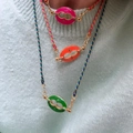 Detalle de collares de cuerda trenzada con colgantes de esmalte coloridos en una modelo - Estilo Esmalte Ovalado / Collar Naranja