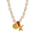 Détail du collier de coquillages avec étoile de mer dorée, corail et disque martelé - Collier de Perles Blanches