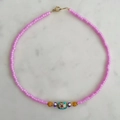 Roze kralenketting met turquoise bloem en roestvrijstalen sluiting op marmer - Roze en Gouden Kralenketting