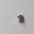 Détail d'une breloque chiffre 1 argentée ornée de trois petits strass brillants de luxe - Accessoire Numéro 1