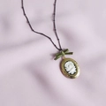 Vintage gouden medaillon ketting met witte roos cameo en groen lint aan zwarte kralenketting - Roos Ovaal