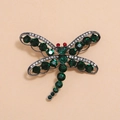 Détail de la broche libellule ornée de cristaux vert émeraude et de strass rouges aux yeux - Vert KC Or