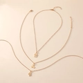 Parure de trois colliers dorés avec pendentifs maison, cerise et geste de la main OK - Or