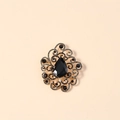 Makroaufnahme der Vintage Goldbrosche mit schwarzem Tropfenstein und filigranem Design - Schwarz Antikgold