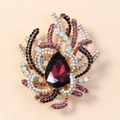Vintage style gold brooch featuring a large red teardrop crystal and purple rhinestones - Purple Antique Gold
