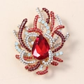 Vintage gold brooch featuring a large red teardrop crystal and small rhinestone accents - Antique Gold Red