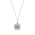 Vintage silver locket necklace with gold sunburst and turquoise bead on white background - Eye Square