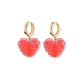 Detailed view of gold hoop earrings with sparkling red 3D resin heart charms - Red Earrings