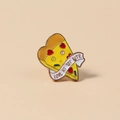 Macro shot of cute pizza enamel pin with heart pepperoni and Love At 1st Bite text - Pizza Style (WBR068)