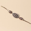 Vista detallada de pulsera vintage dorada con incrustaciones de piedras rojas y verdes - Estilo de Tres Componentes Ovalados (B0599)
