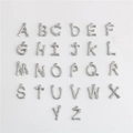 Macro shot of silver bamboo textured alphabet charms A-Z made of durable titanium steel - Letter A / S