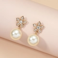 Elegant gold flower pearl earrings with crystals on a minimalist pink display stand - White Flower Pearl Style (EH5563)
