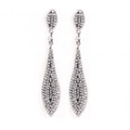 Detailed view of silver dangle earrings with teardrop rhinestones on white board - White Antique Silver