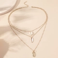 Collana a tre strati dorata con ciondoli a conchiglia naturali su sfondo beige estivo - Oro KC Bianco