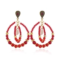 Macro shot of bohemian layered beaded earrings with red stones and natural shell detail - Antique Gold Red