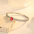 Detailed close-up of a silver bracelet with an oval red gemstone and pavé-set diamonds - Palladium Red Rhinestone (ZX370)