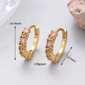 Macro shot of gold huggie earrings featuring pink zircons and white pavé crystals - 14K Gold Pink Zirconia Style (H-14081)