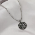Detalle del relieve del escudo de Surinam en colgante de moneda plateada con cadena box - Moneda Emblema Surinam (GX0048)