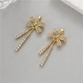 Detailed close-up of bow-shaped gold pendants with clear zircons and flowing tassels - Butterfly Knot Tassel Style (H-10347)