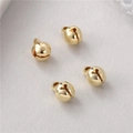 Makro-Detail von vier polierten 14K vergoldeten Kupferglocken für DIY-Schmuck - 6mm Stil / Gold