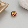 Macro detail of a 14K gold plated evil eye bead with red and white enamel for DIY jewelry - Red
