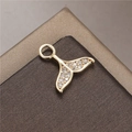 Detailed macro shot of a golden fish tail pendant with micro-paved zircons on a dark base - Whale Tail Shape (H-8779)