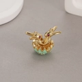 Detailed close-up of rabbit pendant with gold finish, green enamel shell and red crystals - Green