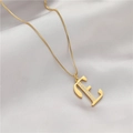 Nahaufnahme der goldenen Kette mit Buchstabe E Anhänger und Zirkonia auf Satinstoff - Buchstabe E (GX0028-E) / Gold