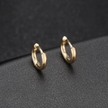 Polished 14k gold-plated huggie earrings on a black leather surface for a vintage look - Round Style (H-7027)