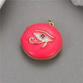 Detail of pink enamel Eye of Horus locket with gold plating and red gemstone inlay - Rose Red