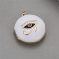 Macro detail of Eye of Horus photo locket with red gemstone and white enamel finish - White