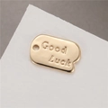 Polished 14K gold plated rectangular Good Luck pendant on white stone display - Good Luck Tag Style (H-7589)