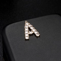 Macro detail of gold letter A pendant with micro-set zircons on black leather - Letter A 14K Gold (H-6575)