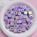 Macro detail of 14mm iridescent purple cube beads with central holes for DIY jewelry - Purple
