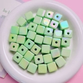 Macro shot of light green square resin beads with AB colorful iridescent coating - Green