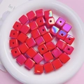 Macro detail of red UV-coated cube beads with iridescent finish for DIY jewelry - Red