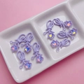 Detailopname van paarse strikbedeltjes met iriserende sterren voor DIY-sieradenaccessoires - Paars