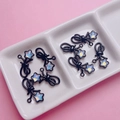 DIY-Zubehör mit schwarzer Schleife und schillernder Sternperle auf einer Keramikschale - Schwarz
