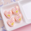 Macro detail of pearlescent pink heart beads with tulip patterns for DIY jewelry - Dense Pink