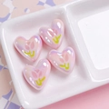 Macro shot of colorful UV-plated heart beads with tulip patterns for DIY jewelry making - Coral Pink